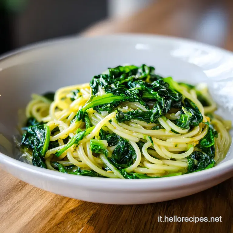 Elegant plate with twirled pasta and spinach. Glossy sauce coats the dish, topped with a dusting of cheese and pepper.