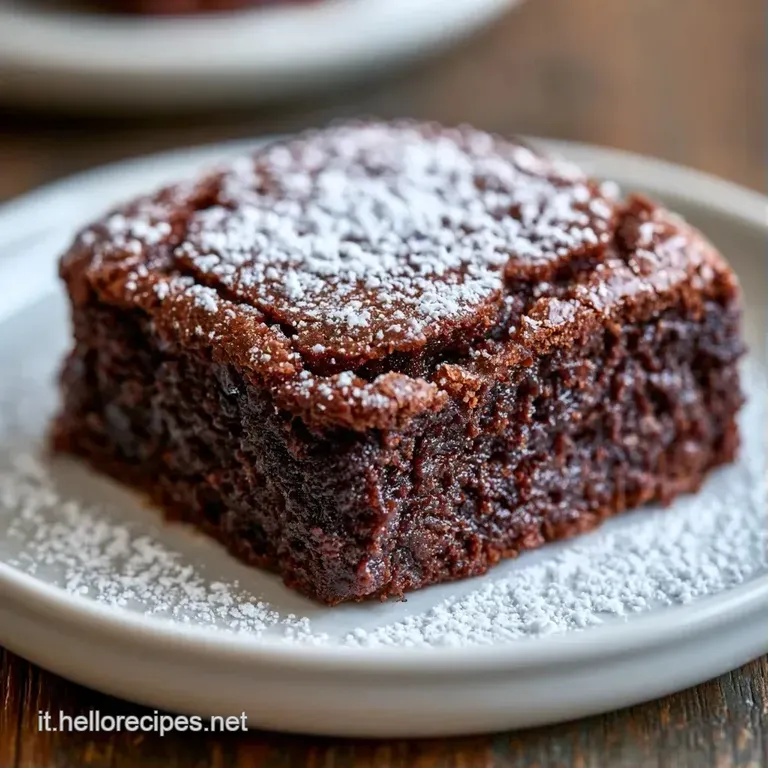 Fetta di dolce al cioccolato su piatto bianco, consistenza densa e umida accompagnata da frutti di bosco rossi freschi.