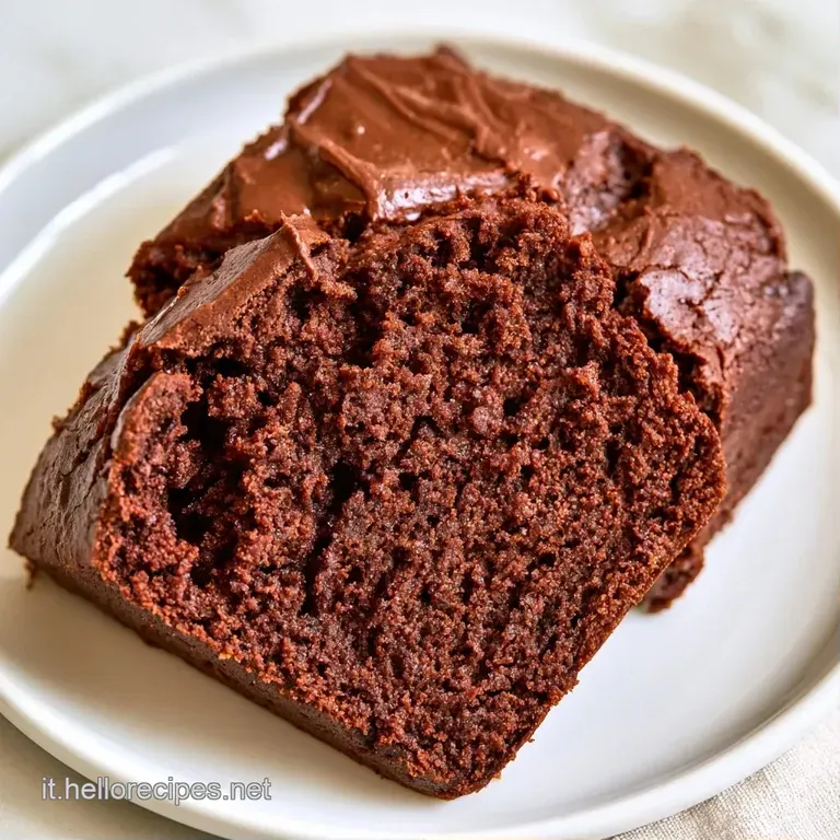 Una fetta di torta al cioccolato densa su piatto bianco, guarnita con fragole rosse e una spolverata di zucchero a velo.